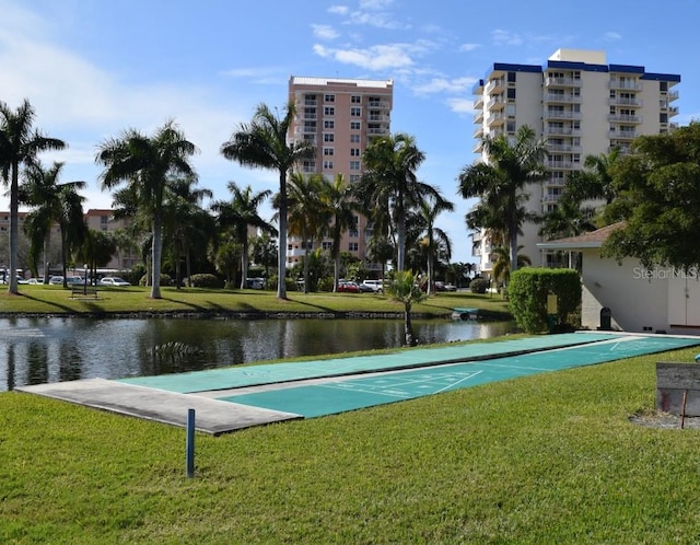 view of home's community featuring a yard, shuffleboard, and a water view