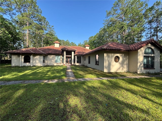 10760 Skylark Dr, Jacksonville, FL 32257 - back of house featuring stucco siding, a lawn, a tile roof, and a chimney