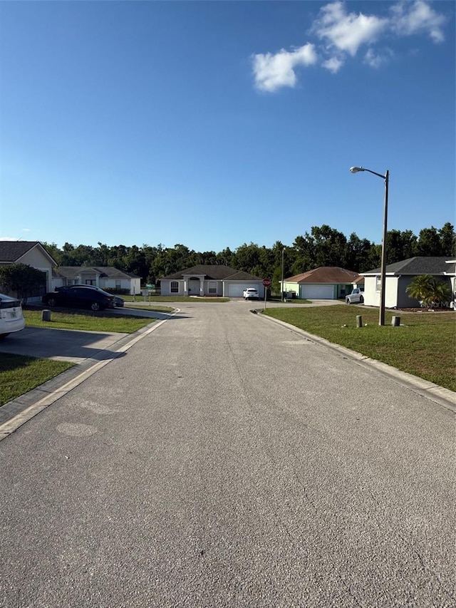 6608 Madeira Ave, Lakeland, FL 33811 - view of asphalt street featuring street lighting, a residential view, and curbs