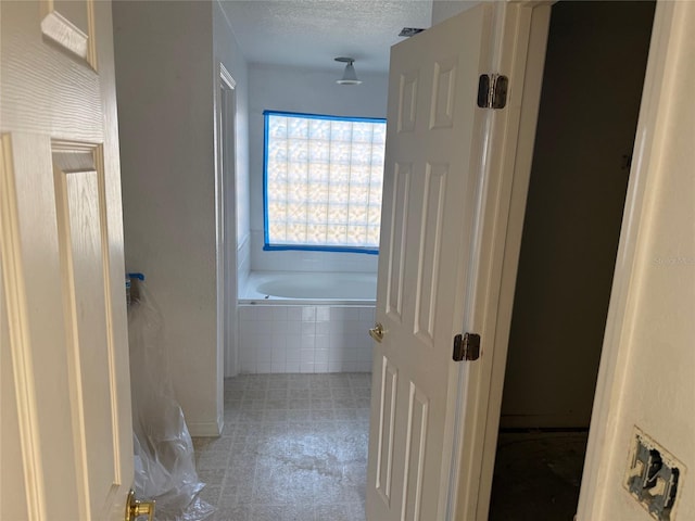 6608 Madeira Ave, Lakeland, FL 33811 - full bath with tiled tub and a textured ceiling