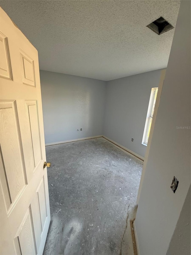 6608 Madeira Ave, Lakeland, FL 33811 - spare room with unfinished concrete floors, baseboards, and a textured ceiling
