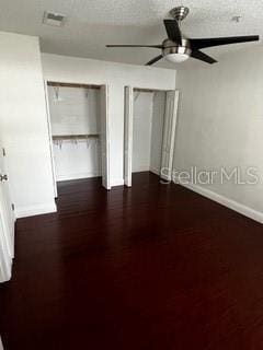 2013 Dixie Belle Dr Unit 2013K, Orlando, FL 32812 - unfurnished bedroom featuring baseboards, ceiling fan, multiple closets, and dark wood finished floors