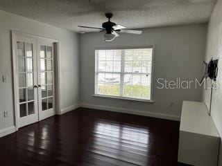 2013 Dixie Belle Dr Unit 2013K, Orlando, FL 32812 - empty room featuring french doors, baseboards, ceiling fan, wood finished floors, and a textured ceiling