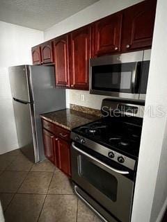 2013 Dixie Belle Dr Unit 2013K, Orlando, FL 32812 - kitchen featuring appliances with stainless steel finishes, dark brown cabinets, tile patterned flooring, and dark countertops