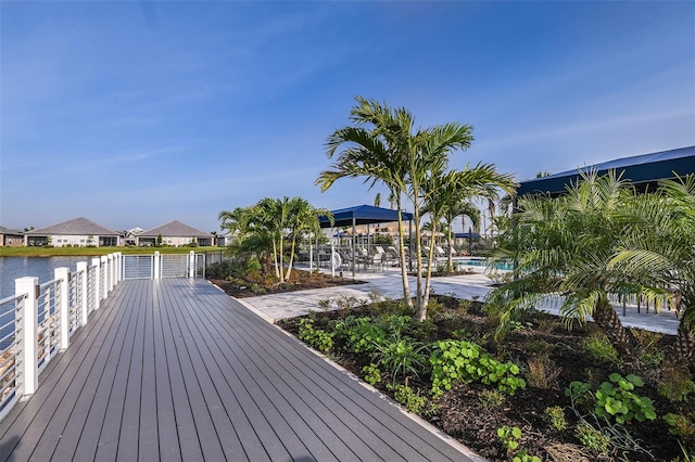 wooden terrace with a community pool and a residential view