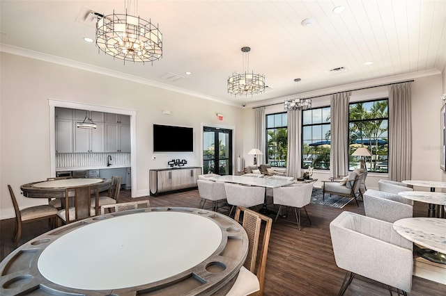 dining room featuring a chandelier, recessed lighting, crown molding, dark wood-style flooring, and baseboards