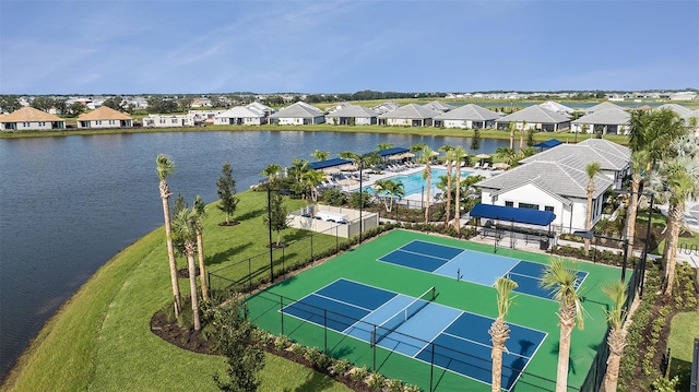 aerial view of residential area with a pool and a large body of water