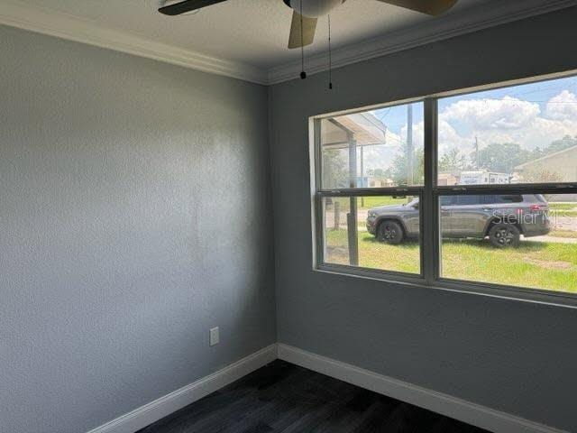 1426 Martin Luther King Jr Ave, Wauchula, FL 33873 - empty room with baseboards, dark wood finished floors, a ceiling fan, and crown molding