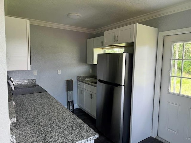 1426 Martin Luther King Jr Ave, Wauchula, FL 33873 - kitchen with freestanding refrigerator, ornamental molding, white cabinets, light stone countertops, and dark wood-style flooring
