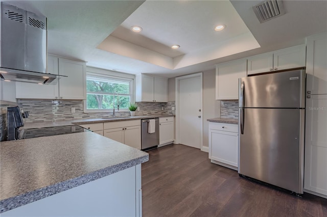 4514 Crichton Ln, Orlando, FL 32806 - kitchen featuring appliances with stainless steel finishes, exhaust hood, a sink, dark wood-type flooring, and a tray ceiling