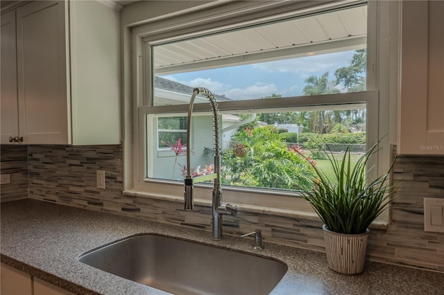 4514 Crichton Ln, Orlando, FL 32806 - kitchen view of tasteful backsplash, a sink, and dark stone countertops