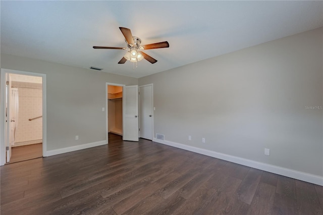 4514 Crichton Ln, Orlando, FL 32806 - unfurnished bedroom with dark wood-style floors, baseboards, a spacious closet, connected bathroom, and ceiling fan