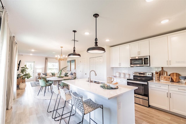 2046 Sunset Preserve Way, Port Charlotte, FL 33953 - kitchen with appliances with stainless steel finishes, a sink, recessed lighting, light wood finished floors, and white cabinetry