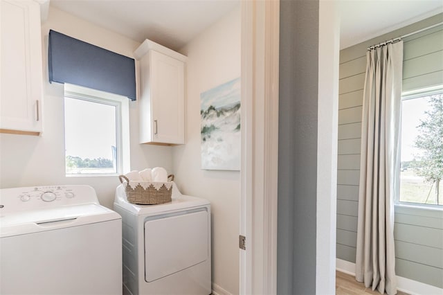 2046 Sunset Preserve Way, Port Charlotte, FL 33953 - laundry area featuring independent washer and dryer, cabinet space, light wood-style floors, and baseboards
