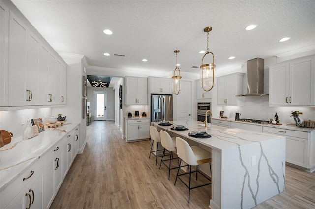 1688 Lugano Cir, North Venice, FL 34275 - kitchen with wall chimney exhaust hood, stainless steel appliances, a breakfast bar area, backsplash, and recessed lighting