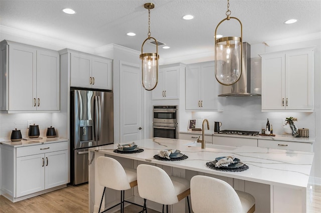 1688 Lugano Cir, North Venice, FL 34275 - kitchen featuring stainless steel appliances, wall chimney range hood, a sink, a breakfast bar, and backsplash