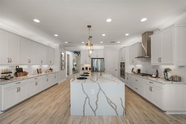 1688 Lugano Cir, North Venice, FL 34275 - kitchen with wall chimney exhaust hood, appliances with stainless steel finishes, white cabinets, hanging light fixtures, and light stone counters