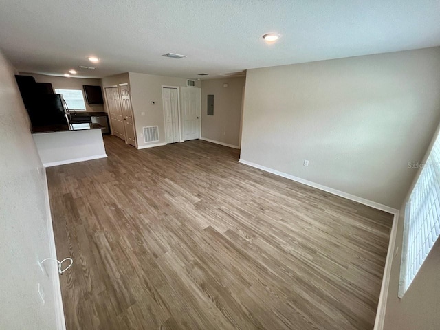 16221 SW 29th Court Rd, Ocala, FL 34473 - unfurnished living room featuring wood finished floors, baseboards, plenty of natural light, recessed lighting, and a textured ceiling