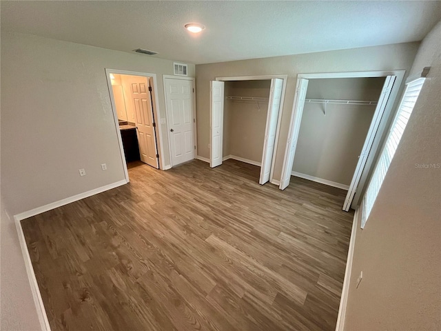 16221 SW 29th Court Rd, Ocala, FL 34473 - unfurnished bedroom with multiple closets, wood finished floors, and baseboards