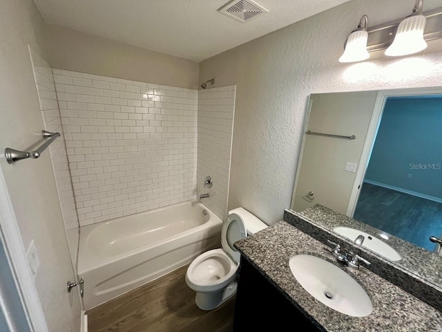 16221 SW 29th Court Rd, Ocala, FL 34473 - bathroom featuring wood finished floors, washtub / shower combination, toilet, vanity, and a textured wall