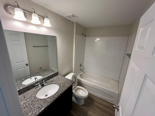 16221 SW 29th Court Rd, Ocala, FL 34473 - bathroom featuring wood finished floors, a textured wall, toilet, a textured ceiling, and shower / bath combination