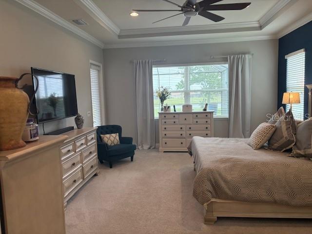 16617 5th Ave E, Bradenton, FL 34212 - bedroom featuring a tray ceiling, light carpet, crown molding, and a ceiling fan