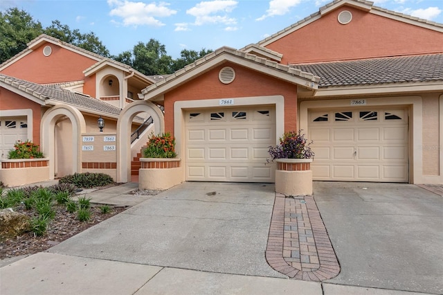 7863 Sugar Bend Dr Unit 7863, Orlando, FL 32819 - view of front of home featuring a tile roof, driveway, stucco siding, and an attached garage