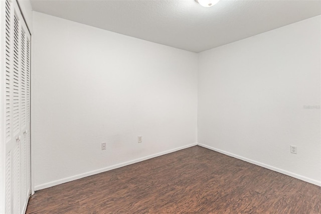 7863 Sugar Bend Dr Unit 7863, Orlando, FL 32819 - unfurnished bedroom featuring dark wood-style flooring, a closet, and baseboards