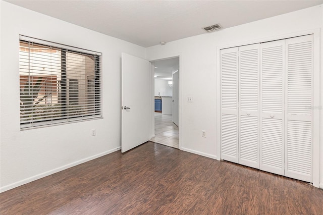 7863 Sugar Bend Dr Unit 7863, Orlando, FL 32819 - unfurnished bedroom featuring dark wood finished floors, baseboards, and a closet