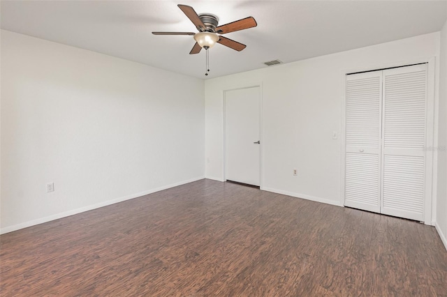 7863 Sugar Bend Dr Unit 7863, Orlando, FL 32819 - unfurnished bedroom featuring dark wood-type flooring, baseboards, a closet, and a ceiling fan