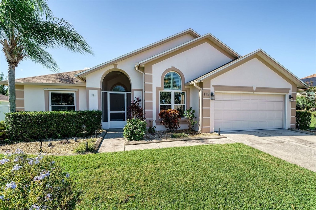 115 Henue Ct, Davenport, FL 33896 - view of front of property with stucco siding, an attached garage, concrete driveway, and a front yard