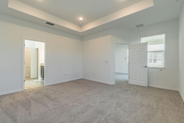 16866 Fiesta Dr, Port Charlotte, FL 33953 - unfurnished bedroom featuring light carpet, a raised ceiling, recessed lighting, and connected bathroom