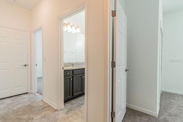 16866 Fiesta Dr, Port Charlotte, FL 33953 - hallway with a sink and light carpet