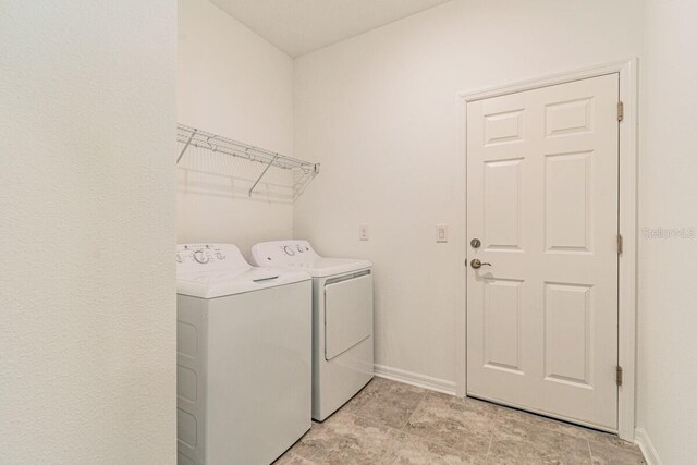 16866 Fiesta Dr, Port Charlotte, FL 33953 - laundry area with washing machine and dryer and baseboards