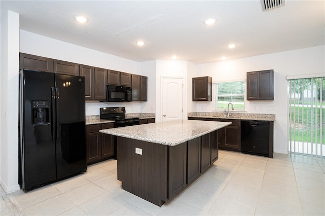 3850 Hampstead Ln, Lakeland, FL 33810 - kitchen with black appliances, dark brown cabinets, a kitchen island, light stone counters, and recessed lighting