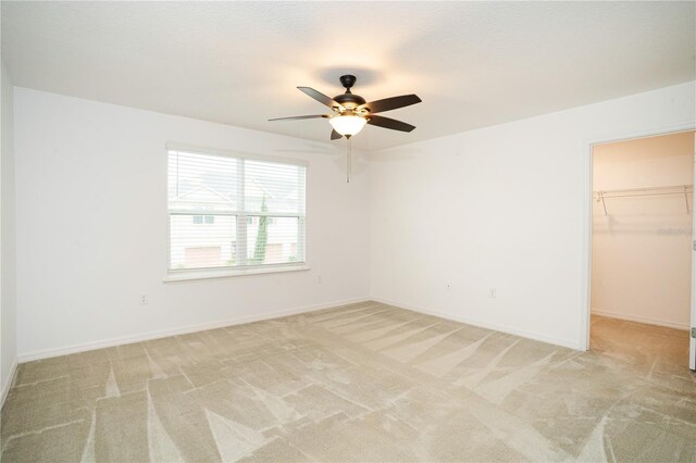 3850 Hampstead Ln, Lakeland, FL 33810 - unfurnished bedroom featuring light carpet, a walk in closet, a ceiling fan, and a closet