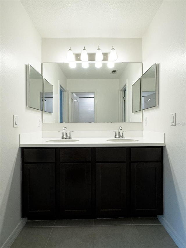 3850 Hampstead Ln, Lakeland, FL 33810 - bathroom with double vanity, tile patterned floors, and a textured ceiling