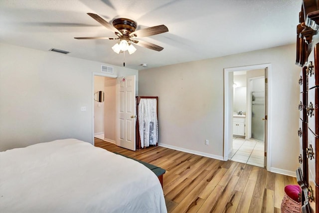 130 Evergreen Dr, Auburndale, FL 33823 - bedroom with light wood-style floors, a ceiling fan, and connected bathroom