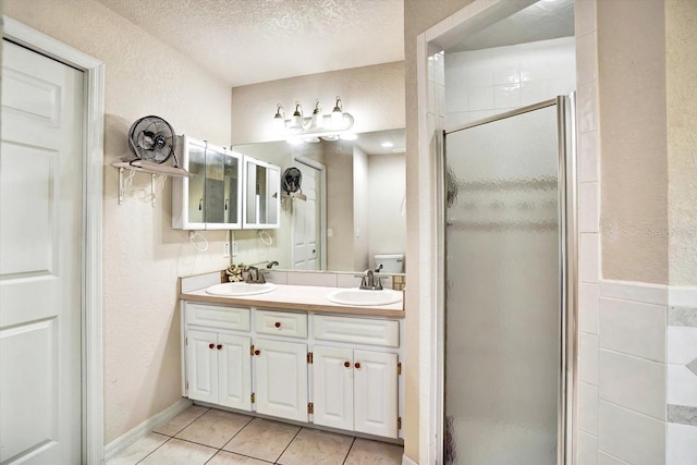 130 Evergreen Dr, Auburndale, FL 33823 - full bathroom with a stall shower, double vanity, a textured wall, tile patterned floors, and a textured ceiling