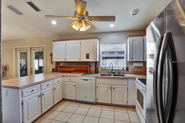 130 Evergreen Dr, Auburndale, FL 33823 - kitchen featuring white appliances, a peninsula, healthy amount of natural light, and light tile patterned flooring