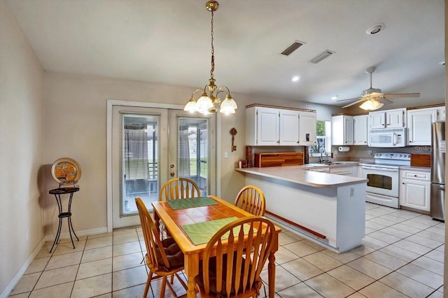130 Evergreen Dr, Auburndale, FL 33823 - kitchen with white appliances, a peninsula, white cabinets, light tile patterned floors, and a chandelier