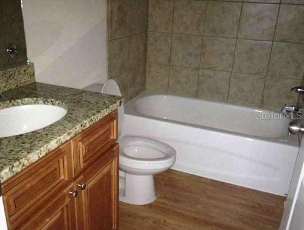 301 NW 8th St, Gainesville, FL 32601 - bathroom featuring wood finished floors, vanity, and tub / shower combination