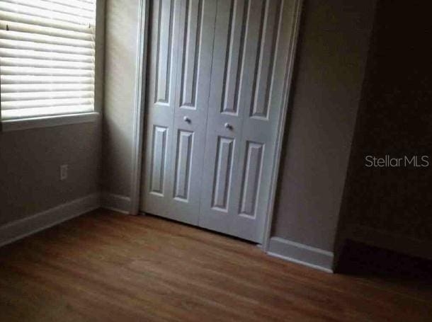 301 NW 8th St, Gainesville, FL 32601 - unfurnished bedroom with wood finished floors and a closet