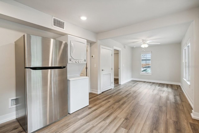 302 NW 7th Ter, Gainesville, FL 32601 - kitchen featuring freestanding refrigerator, stacked washing machine and dryer, light wood-type flooring, a ceiling fan, and light countertops