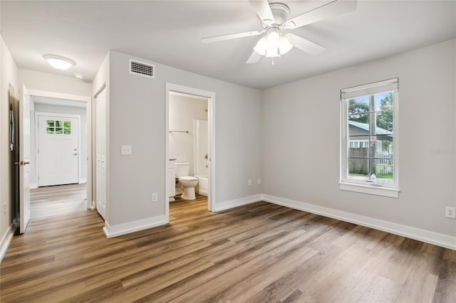 302 NW 7th Ter, Gainesville, FL 32601 - unfurnished bedroom with wood finished floors, ensuite bathroom, and ceiling fan