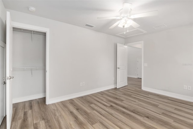 302 NW 7th Ter, Gainesville, FL 32601 - unfurnished bedroom with wood finished floors, a closet, a ceiling fan, and attic access