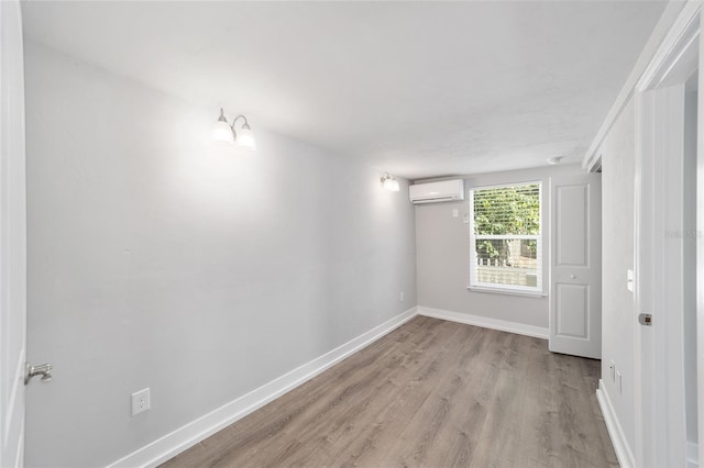 302 NW 7th Ter, Gainesville, FL 32601 - empty room with a wall unit AC and light wood-style floors