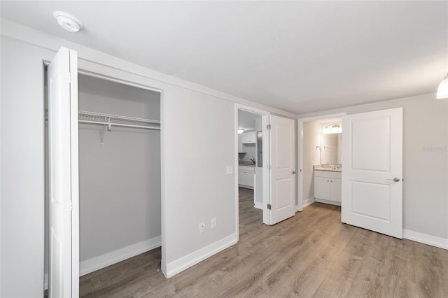 302 NW 7th Ter, Gainesville, FL 32601 - unfurnished bedroom with light wood finished floors, ensuite bathroom, and a closet
