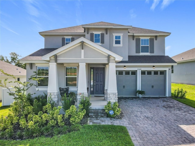 2044 Keystone Pass Blvd, Minneola, FL 34715 - view of front of house featuring stucco siding, a garage, roof with shingles, and decorative driveway