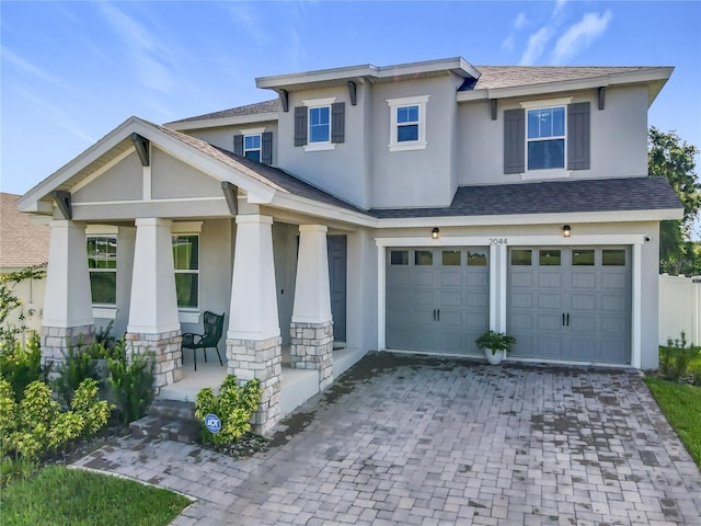 2044 Keystone Pass Blvd, Minneola, FL 34715 - view of front facade featuring stucco siding, a porch, decorative driveway, stone siding, and an attached garage